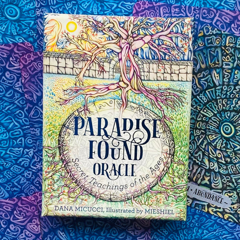 Paradise Found orakulo kortos su iliustruota dėžute, matomas priekinis medis, ornamentinis fonas ir pavadinimas