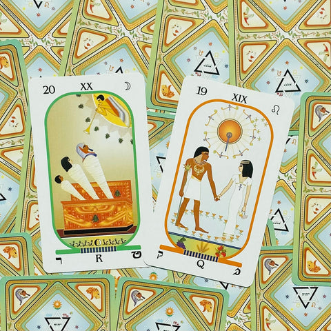 Tarot kortos su egiptietišku dizainu, dvi atvertos didžiosios arkana kortos ant raštuoto žalių kortų galinių pusių fono