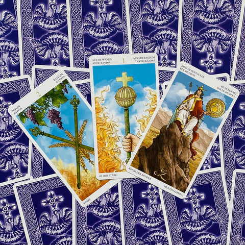 tarot kortos trijų kortų išdėstymas su mėlynais nugarėlių raštais, centre Ąsas lazdų, 2 lazdų ir Monetų karalius