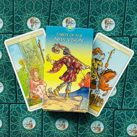 Tarot kortos "New Vision" pilnas denis su dėkle centre, dvi išverstinės kortos šonuose ir žalio rašto nugarėlės fone