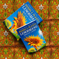 Lenormand kortos Herbs & Plants mėlyname dėkle su saulėgrąžos dizainu, dvi dėžutės iš viršaus ant raštuoto fono