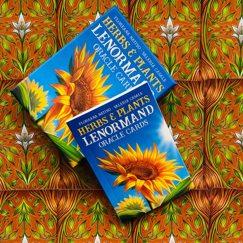 Lenormand kortos Herbs & Plants mėlyname dėkle su saulėgrąžos dizainu, dvi dėžutės iš viršaus ant raštuoto fono