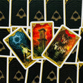 tarot kortos su aukso rėmeliais, trijų didžiųjų arkanų išdėstymas (Bokštas, Velnis, Žvaigždė) ant juodų nugarėlių — galerijos variantas