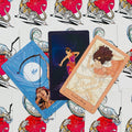 Tarot kortos meninis rinkinys — trys atverstos kortos (mėlyna, juoda, persikų), plokščiai išdėstytos ant tigro nugarėlių