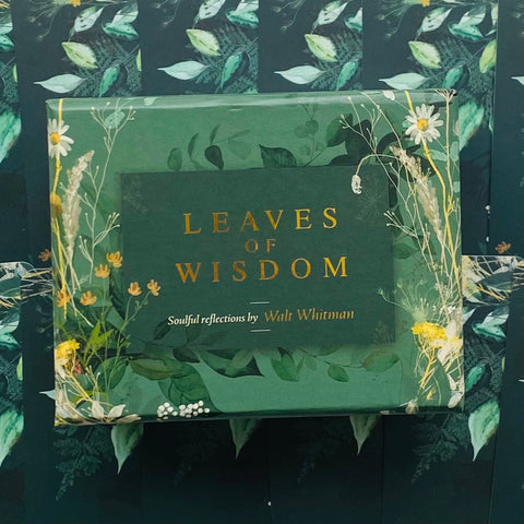 Knyga Leaves of Wisdom su žaliu viršeliu, auksinėmis raidėmis ir gėlių rėmeliu, arti priekinis rodinys aptrauktas plėvele