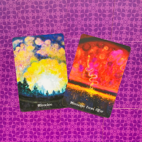 Tarot kortos dvi priekinės kortos: geltonai‑mėlyna Miracles ir ryškiai raudona Message from Afar ant violetinio rašto fono