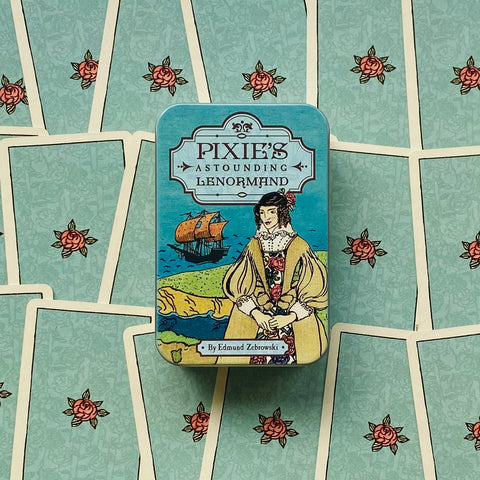 Lenormand kortų rinkinys Pixie's metalinėje turkio spalvos dėžutėje, centre uždarytas ant išskleistų kortų fono