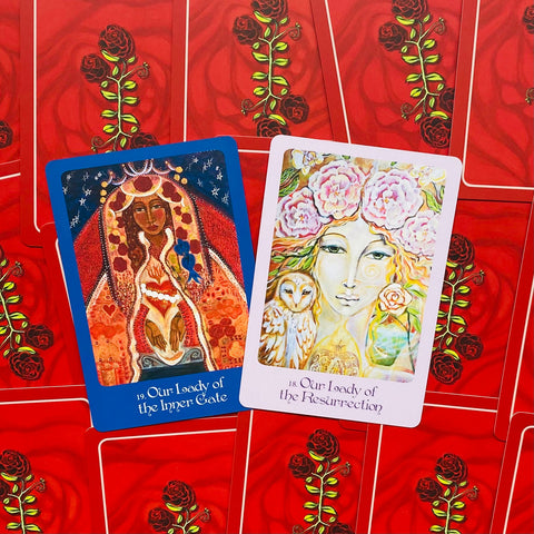Tarot kortos atvertos dvi: mėlyna Our Lady of the Inner Gate ir rožinė Our Lady of the Resurrection, raudonas rožių nugarėlių fonas