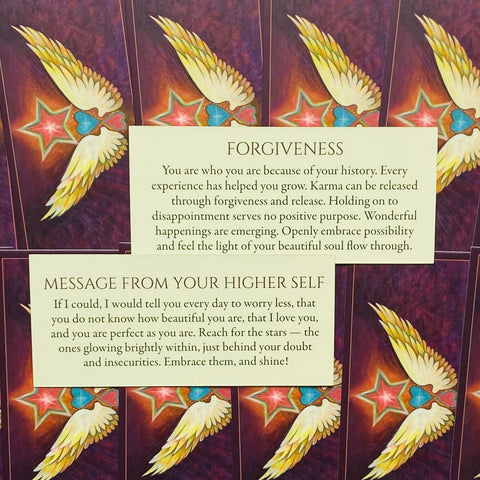 kortų rinkinys su violetiniu fonu ir sparnų motyvais, parodytos tekstinės kortos Forgiveness ir Message from Your Higher Self, skirtos savirefleksijai