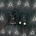 Tarot kortos juodos baltos mėnulio iliustracijos, dvi išklotos kortos, rodančios unikalų priekį ir nugarėlės dizainą