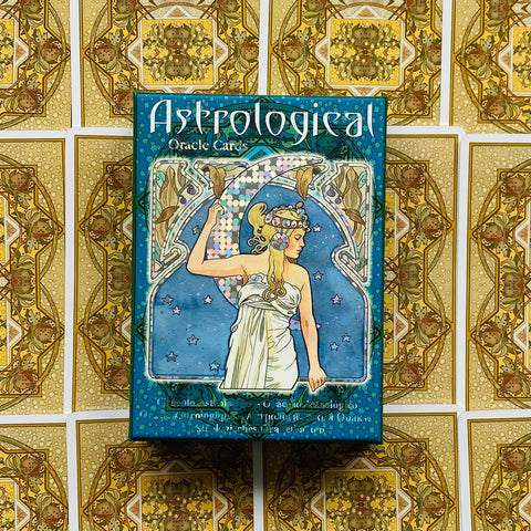 Astrological orakulo kortos mėlyname dėkle su holografiniu pusmėnulio motyvu, centre ant aukso raštuoto kortų fono