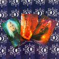 Tarot kortos komplektas su trimis priekinėmis kortomis (žalia, oranžinė, raudona), išdėstytos ant violetinio nugarėlių dizaino fono
