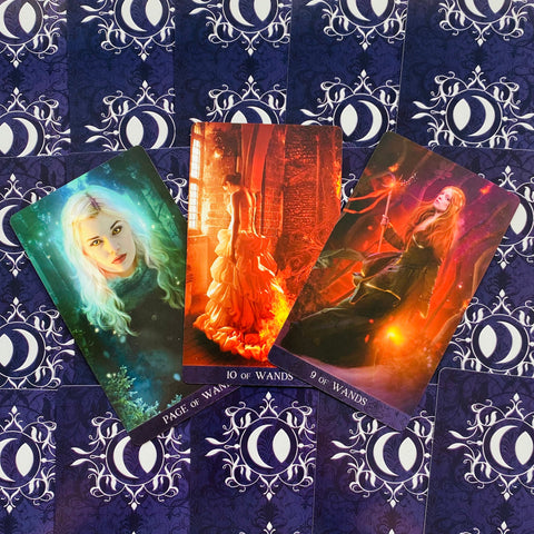 Tarot kortos komplektas su trimis priekinėmis kortomis (žalia, oranžinė, raudona), išdėstytos ant violetinio nugarėlių dizaino fono