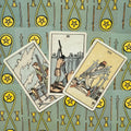 Tarot kortos trys Kardų kortos (V–VII) išdėstytos ant žalsvo pentaklių rašto fono, užfiksuota iš arti kampu