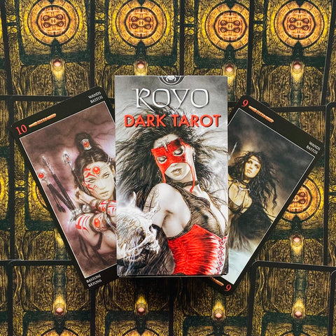 Taro kortų rinkinys Royo Dark Tarot – centrinė dėžutė su raudona kauke ir korsetu bei dvi atverstos kortos ant ornamentinių nugarėlių fono