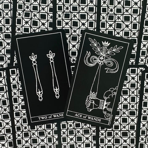 Taro kortos juodos‑baltos, Ace of Wands ir Two of Wands kortos išdėstytos ant geometrinio nugarėlių rašto, variantas su atversta priekine puse
