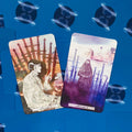tarot kortos, dvi kortos iš arti: Swords 9 su rausvai‑oranžiniais tonais ir Swords 8 violetinėmis, nufotografuotos iš viršaus ant mėlyno fono