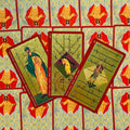 Tarot kortos, auksinio ir raudono dizaino Bastonų kortų trio (9, 10 ir riteris), išdėstyti ant ornamentuotų nugarėlių