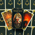 Tarot kortos Night Sun – Fabio Listrani juoda su auksiniais ornamentais dėžutė centre, išskleistų kortų fone