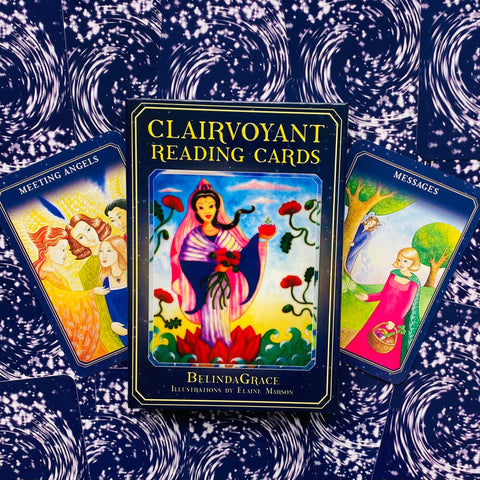 tarot kortos BelindaGrace tamsiai mėlyname dėkle su spalvingomis iliustruotomis kortomis, rodoma iš priekio ant žvaigždėto fono