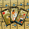 tarot kortos aukso folija — egiptietiškos didžiųjų arkana trys kortos ant akių raštuoto dėklo, pasvirusios