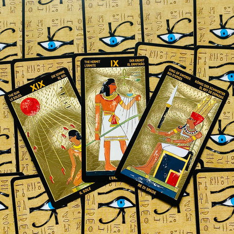 tarot kortos aukso folija — egiptietiškos didžiųjų arkana trys kortos ant akių raštuoto dėklo, pasvirusios