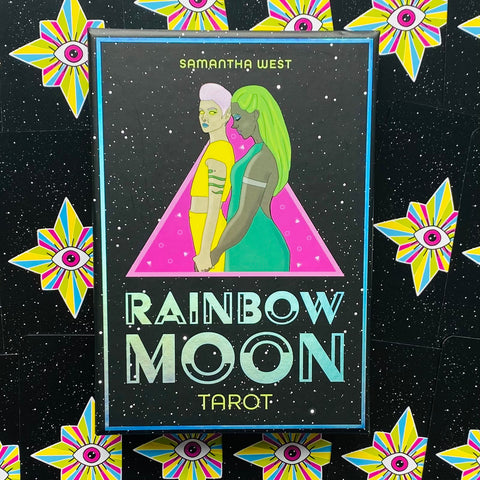 Tarot kortos Rainbow Moon — juoda dėžutė su neoninėmis figūromis, ryškiu rožiniu trikampiu ir žvaigždėtu fonu