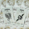 Tarot kortos NITHAIAH ir HAHUIAH baltame fone, aukštas kampas, matomi kortų priekiai ir auksiniai simboliai
