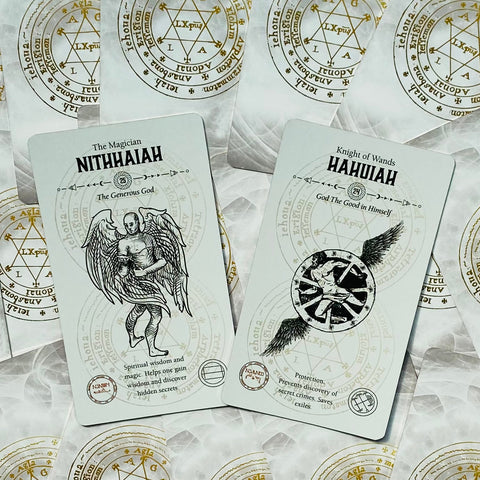 Tarot kortos NITHAIAH ir HAHUIAH baltame fone, aukštas kampas, matomi kortų priekiai ir auksiniai simboliai