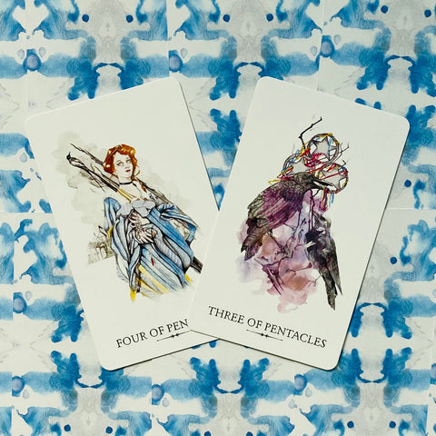 Tarot kortos su akvarelinėmis iliustracijomis — dvi kortos (Four of Pens, Three of Pentacles) ant mėlyno fono, matomas iliustracijų variantas