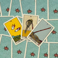 Tarot kortos Rider‑Waite stiliaus, mėlynos rožių nugarėlės, trijų kortų išdėstymas iš viršaus su Scythe, Birds ir Sheaf