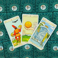 tarot kortos Rider–Waite komplektas, žalia raštuota nugara, trijų kortų išdėstymas parodytas (Pentaklių tūzas, 2 Pentakliai, Taurų karalius)