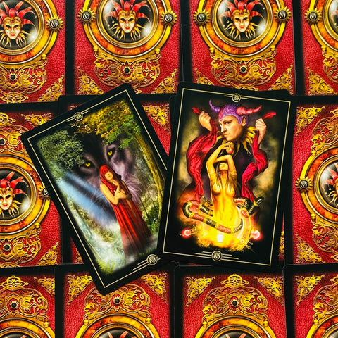 Tarot kortos su dviem atverstomis kortomis – vilko ir liepsnos motyvais, ant raudonų ornamentuotų nugarėlių, dekoratyvus variantas parduotuvės galerijoje