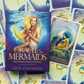 Oracle of the Mermaids kortų kaladė Lucy Cavendish purpuriniame dėkle, matoma dėžutės priekinė iliustracija ir viena atversta korta su nėščia jūros deive