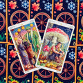 tarot kortos — dvi Pentaklių kortos (5 ir 6) išdėstytos įstrižai, ryškios iliustracijos ir ornamentuota nugarėlė matoma
