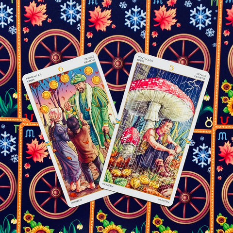 tarot kortos — dvi Pentaklių kortos (5 ir 6) išdėstytos įstrižai, ryškios iliustracijos ir ornamentuota nugarėlė matoma