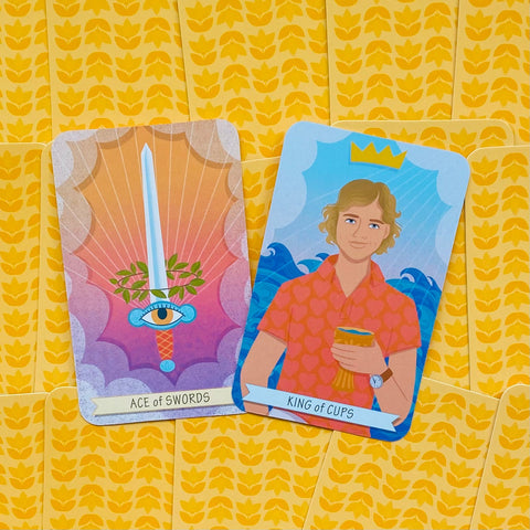 Tarot kortos su geltonomis nugarėlėmis, parodytos dvi priešingos kortos: Ace of Swords (kalavijas) ir King of Cups