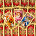 Kortos Lenormand, trys atvertos kortos (Lapė 14, Vaikas 13, Paukščiai 12) ant raudonų auksuotos nugarėlės, artimas kampinis planas