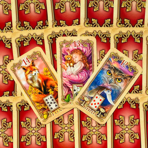 Kortos Lenormand, trys atvertos kortos (Lapė 14, Vaikas 13, Paukščiai 12) ant raudonų auksuotos nugarėlės, artimas kampinis planas