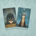 Tarot kortos komplektas: dvi kortos (Three of Swords, Two of Swords) ant turkio fono, kampu nusuktos, akcentuojančios kardų motyvus ir skirtingus paveikslų dizainus