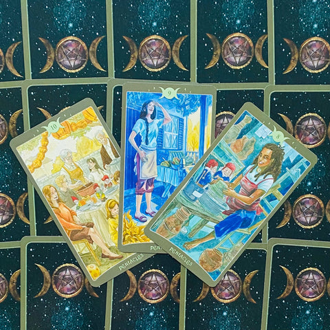 tarot kortos atverstos trys Pentaklių kortos su akvareliniais piešiniais ir mėlynomis nugarėlėmis su trijų mėnulio simboliu