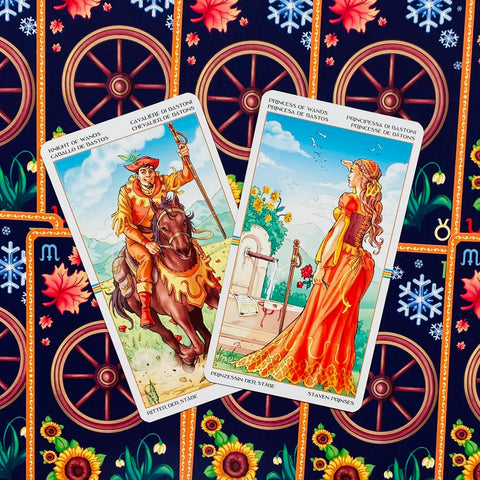 Tarot kortos su dviem Lazdų rūšies kortomis (Riteris ir Princesė), ryškūs oranžiniai atspalviai ant dekoratyvaus audinio