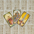 Tarot kortos Rider–Waite stiliaus, trys atvertos kortos fanuotos ant ornamentuotų nugarėlių fono, plokščias išdėstymas