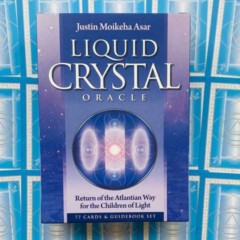 Liquid Crystal oracle kortų rinkinys mėlynoje dėžutėje su 77 kortomis ir vadovu, pabrėžiantis priekinį dizainą