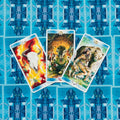 Tarot kortos su mėlynais nugarėlių raštais, trys atviros kortos (centre statmena, kairė ir dešinė pasvirusios) skirtos skaitymui