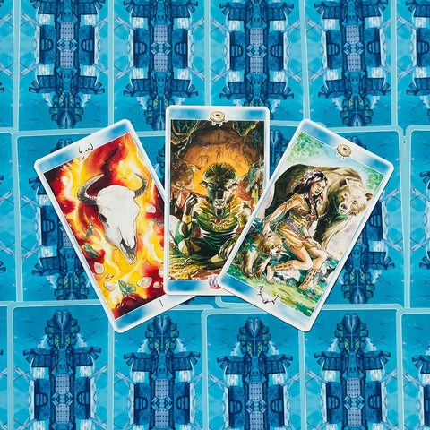 Tarot kortos su mėlynais nugarėlių raštais, trys atviros kortos (centre statmena, kairė ir dešinė pasvirusios) skirtos skaitymui