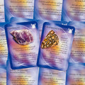 Orakulinių kortų rinkinys su Lepidolite ir Leopardskin Jasper kortelėmis, artimas kampas, violetinė-mėlyna gradientinė fone, priekinės pusės variantas