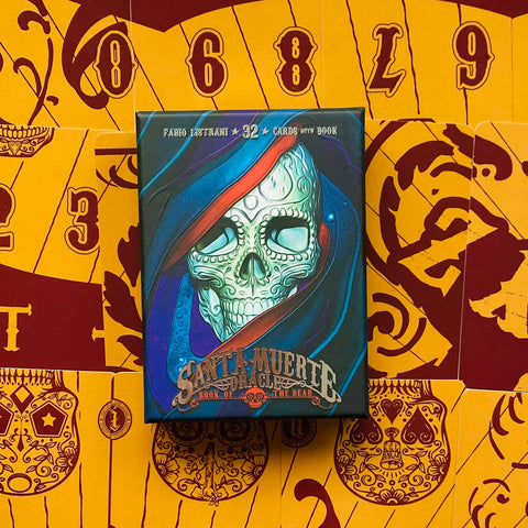 Kortų rinkinys Santa Muerte oracle su 32 kortomis ir knygele, tamsiai mėlyna dėžutė su ornamentuota kaukole ant geltono raštuoto fono