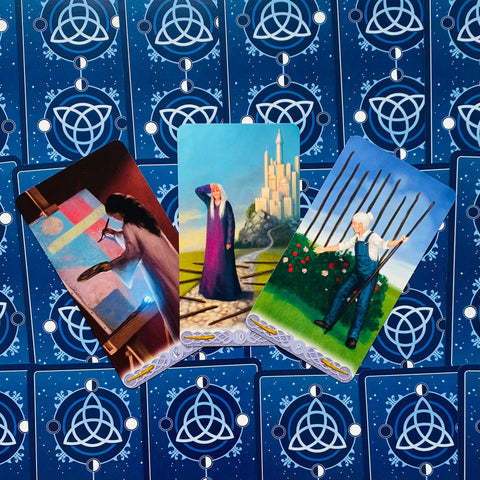 Tarot kortos trijų kortų išdėstymas: mėlynos nugarėlės su trikampio simboliu ir trys atviros, spalvotos iliustracijos