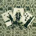 Tarot kortos rinkinys: trys juodai baltos iliustruotos kortos išfanuotos ant ornamentuoto fono, akcentuojančios skirtingus simbolius